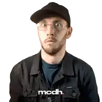 a man wearing glasses and a hat with the word mcdh on the bottom right