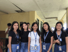 a group of girls are posing for a picture and the word ok is on the bottom right