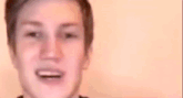a young man is holding a cell phone in his hand and talking to it .