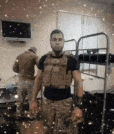 a man in a military uniform is standing in a room next to a bunk bed .