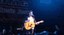 a man singing into a microphone while playing a guitar