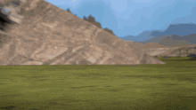 a blurred image of a field with a mountain in the background