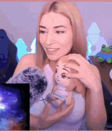 a woman holding a stuffed animal with a frog in the background