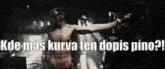 a shirtless man is holding a gun in a dark room with the words kde mas kurva ten dopis pino