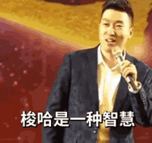 a man in a suit is holding a microphone in front of a red background