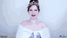 a woman wearing a tiara and pearls is smiling and wearing a fur coat .