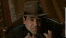 a man in a suit and tie is saying you 're a ox and a moron in a meme .