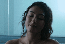 a woman is taking a bath with her eyes closed and her hair is wet .