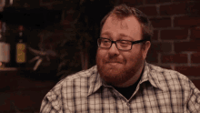 a man with glasses and a beard is smiling