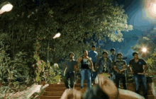 a group of people walking down stairs at night with one wearing a shirt that says ' avengers ' on it