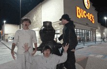 a group of people pose in front of a buck ee 's restaurant