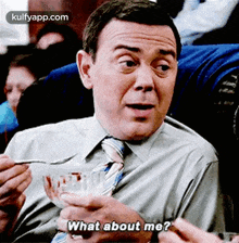 a man in a suit and tie is holding a bowl of food and asking what about me