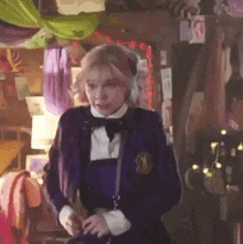 a woman in a purple school uniform is standing in a room with a lot of decorations .