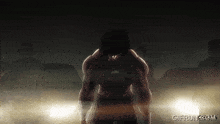 a man is standing in a dark room with the words gifrun.com written below him