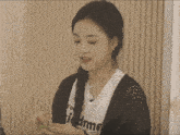 a woman wearing a black cardigan and a white t-shirt that says i 'd me