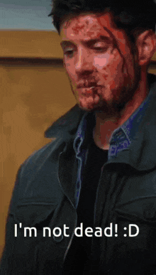 a man with blood on his face and the words " i 'm not dead " below him