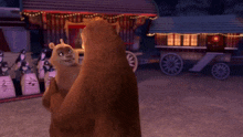 a couple of bears standing next to each other in front of a building