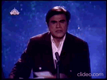 a man in a suit is giving a speech at a podium .