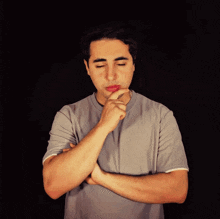 a young man with his eyes closed and his hands folded