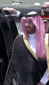 a man in a traditional arabian costume is getting out of a car