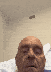a man with his eyes closed is laying on a bed