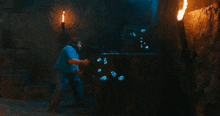 a man in a blue shirt is standing in front of a large treasure chest