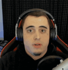 a man wearing headphones is looking at the camera and making a funny face