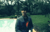 a man in a suit and a superman shirt is standing in front of a pool