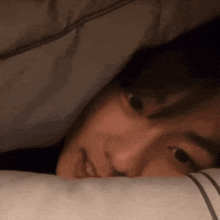 a close up of a person laying in bed with their head on a pillow