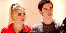a man and a woman are standing next to each other and the man is asking the woman if she has trouble .