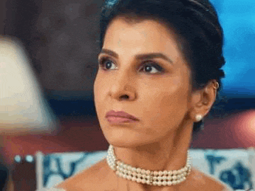 a close up of a woman wearing a pearl choker necklace .