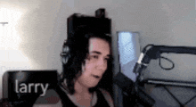 a man wearing headphones is talking into a microphone in a room .