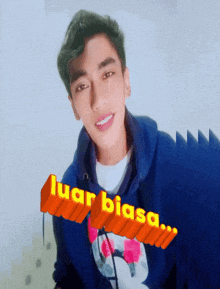 a young man wearing a blue hoodie with the word luar biasa written on it
