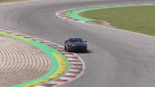 a gray sports car is driving on a race track