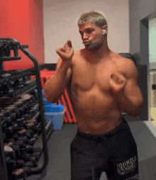 a shirtless man wearing a pair of black shorts that say young on them