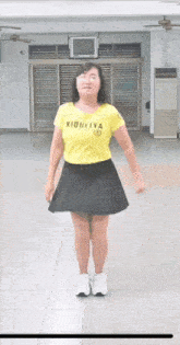 a woman wearing a yellow shirt that says xiaoliya on it