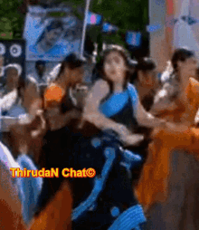 a group of people are dancing in front of a sign that says thirudan chato