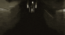 a dark hallway with a light coming out of the door