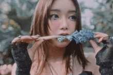 a woman holding a flower in her mouth