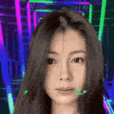a close up of a woman 's face with neon lights in the background and a green pixel that says ' s ' on it