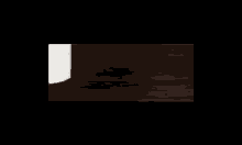 a person is standing in a dark room with a light coming through the door .