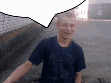 a boy in a blue shirt is smiling with a speech bubble behind him