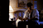 a man is sitting on a bed reading a book called ' a few lines '