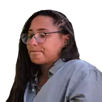 a woman wearing glasses and a grey shirt looks to the side