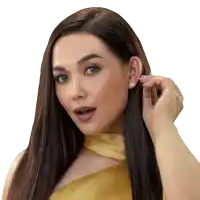 a woman in a yellow dress is adjusting her earrings