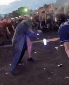 a man in a blue coat is dancing in a crowd with a sign that says x on it