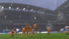 a blurry picture of a soccer game with a yellow ball flying through the air