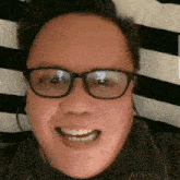 a man wearing glasses and headphones is smiling and making a funny face