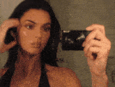 a woman is taking a selfie in front of a mirror .