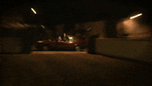 a blurry picture of a red car with a yellow light in the background
